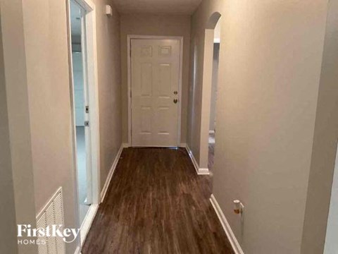 a hallway with a white door and wooden floors