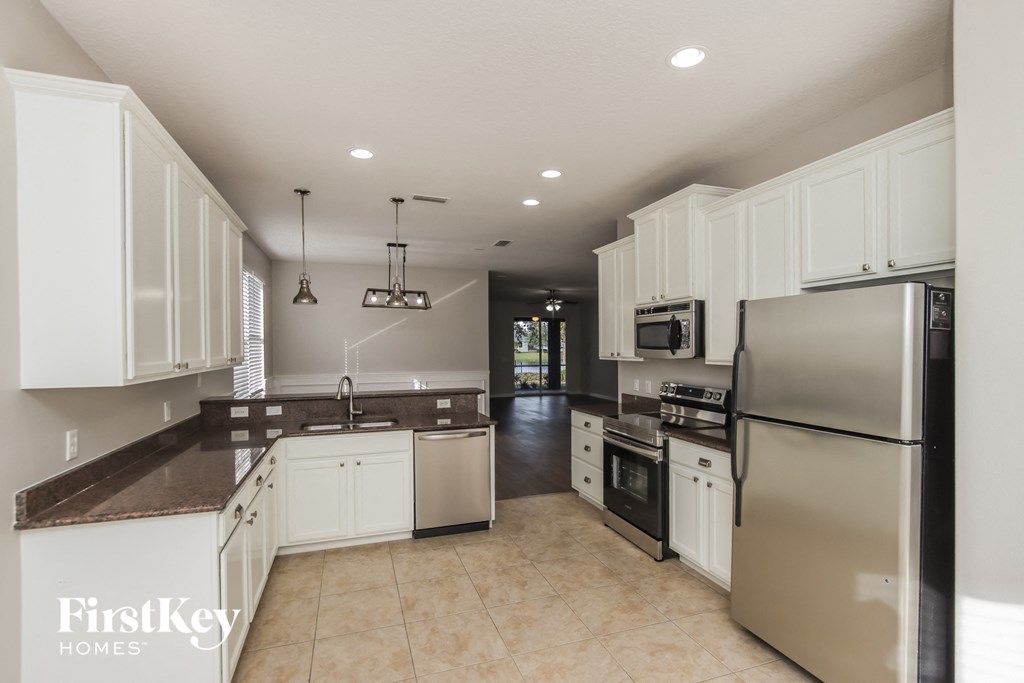 a kitchen with white cabinets and stainless steel appliances