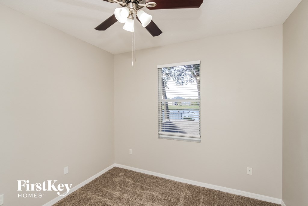 a living room with a ceiling fan and a window