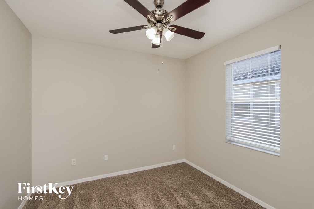 a bedroom with a ceiling fan and a window