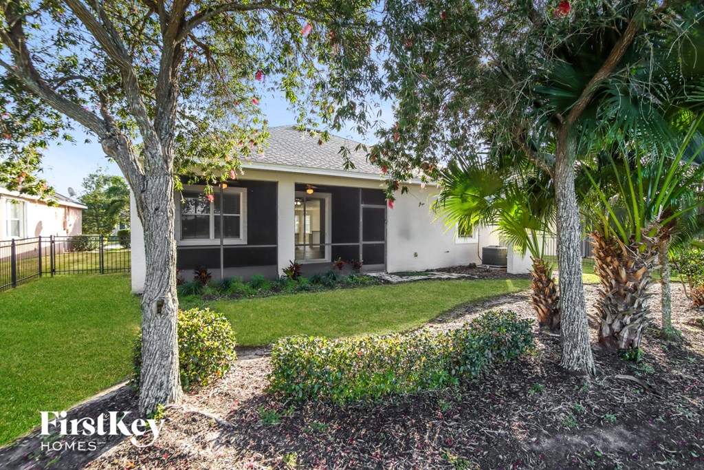 a home with a lawn and trees in front of it