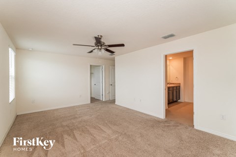 a living room with carpet and a ceiling fan