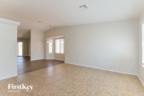 A spacious room with a tiled floor and a window with blinds.