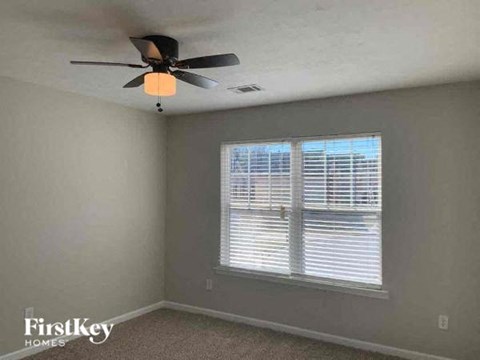 a bedroom with a ceiling fan and a window