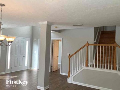 a living room with a staircase and a white door