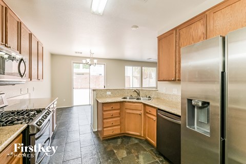 A kitchen with wooden cabinets and a stainless steel refrigerator.