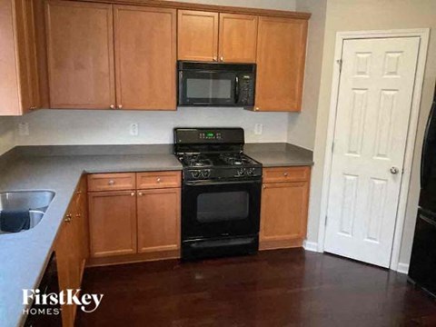 a kitchen with wooden cabinets and a stove and a microwave