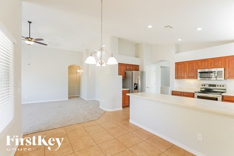 A spacious kitchen with wooden cabinets and a stove top oven.
