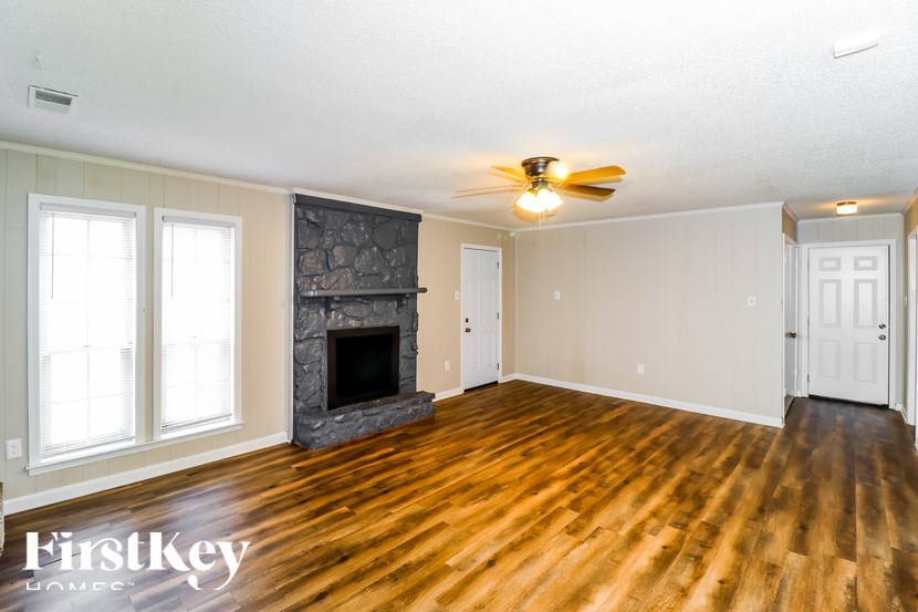 A room with a fireplace and wood flooring.