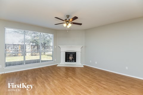 a living room with a fireplace and a ceiling fan