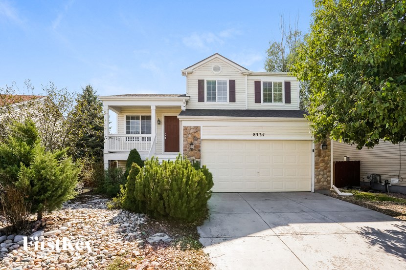 a white house with a white garage door and a driveway