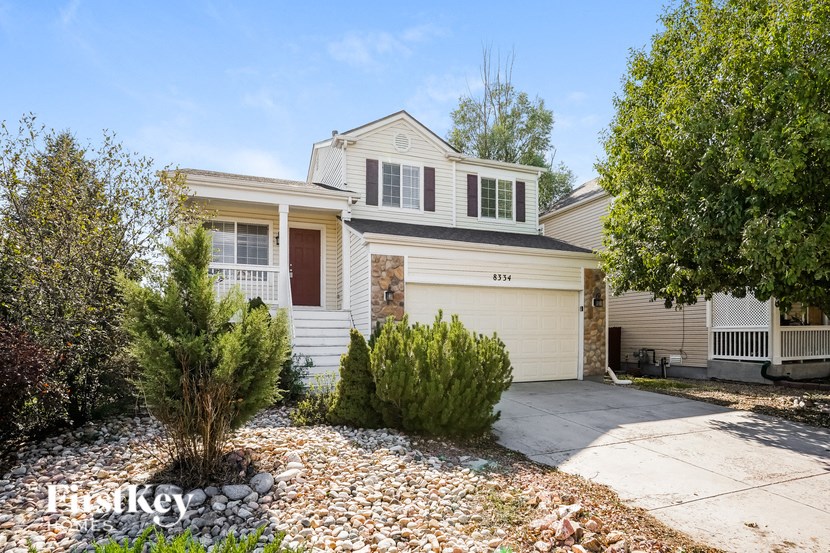 a white house with a garage door and a gravel driveway