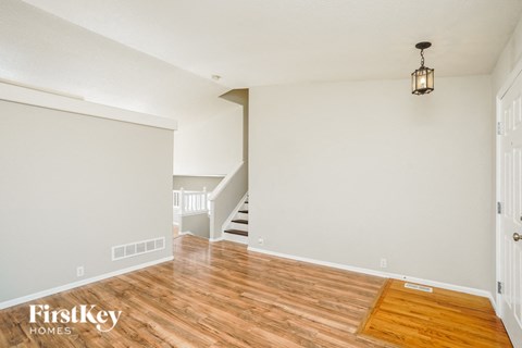 a living room with a hard wood floor and a staircase