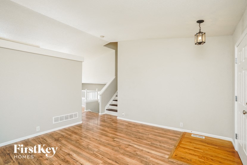 a living room with a hard wood floor and a staircase