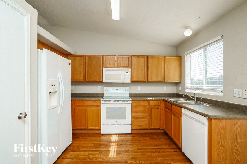 a kitchen with wooden cabinets and white appliances