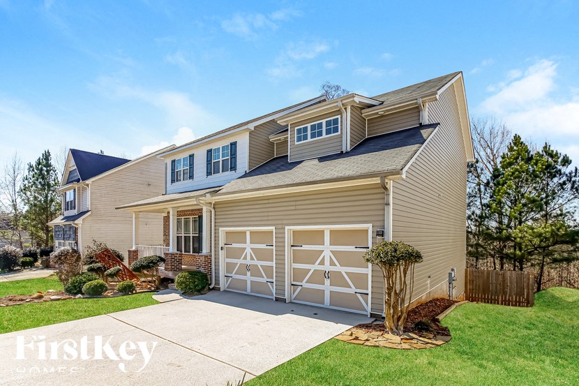 A two-story house with a garage and a driveway.
