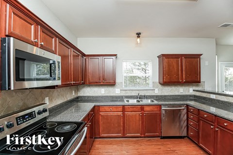 A kitchen with wooden cabinets and a stainless steel oven.