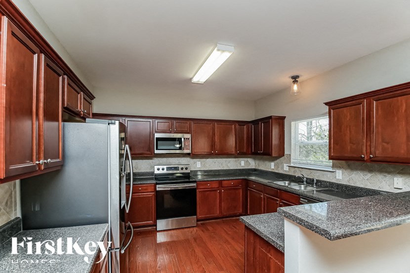 A kitchen with wooden cabinets and a granite countertop.