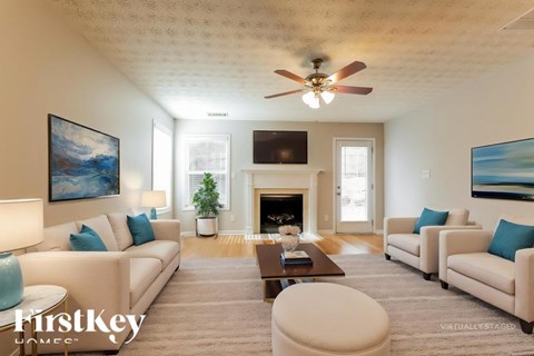 A living room with a fireplace and a painting on the wall.