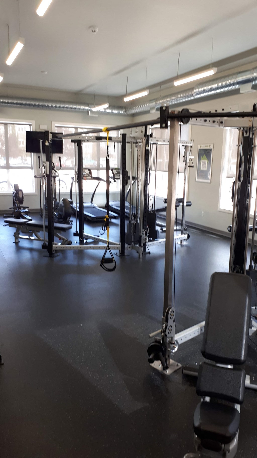 A gym with a row of exercise machines.