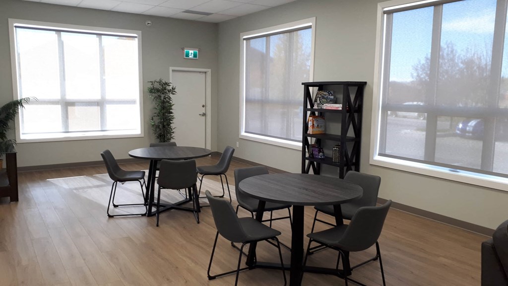 A room with a table and chairs and a plant.
