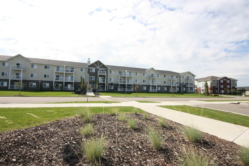 Apartment complex with a grassy area in the foreground.