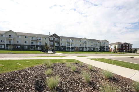 Apartment complex with a grassy area in the foreground.
