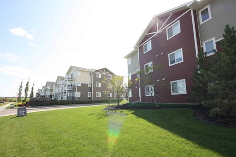 A grassy area in front of apartment buildings.