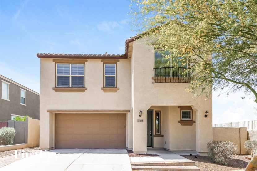 A two-story house with a garage and balcony.