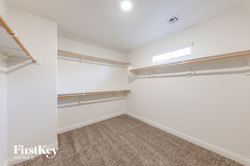 A bedroom with a carpeted floor and a window.