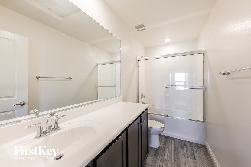 A bathroom with a white sink and a toilet.