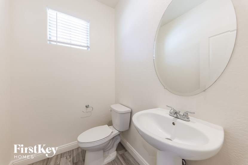 A white toilet and sink in a small bathroom.