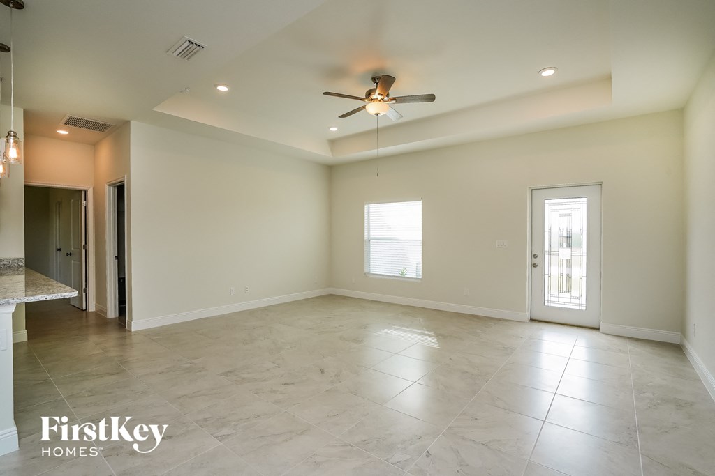 an empty living room with a ceiling fan