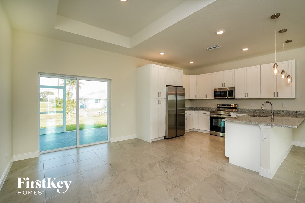 a large kitchen with white cabinets and stainless steel appliances