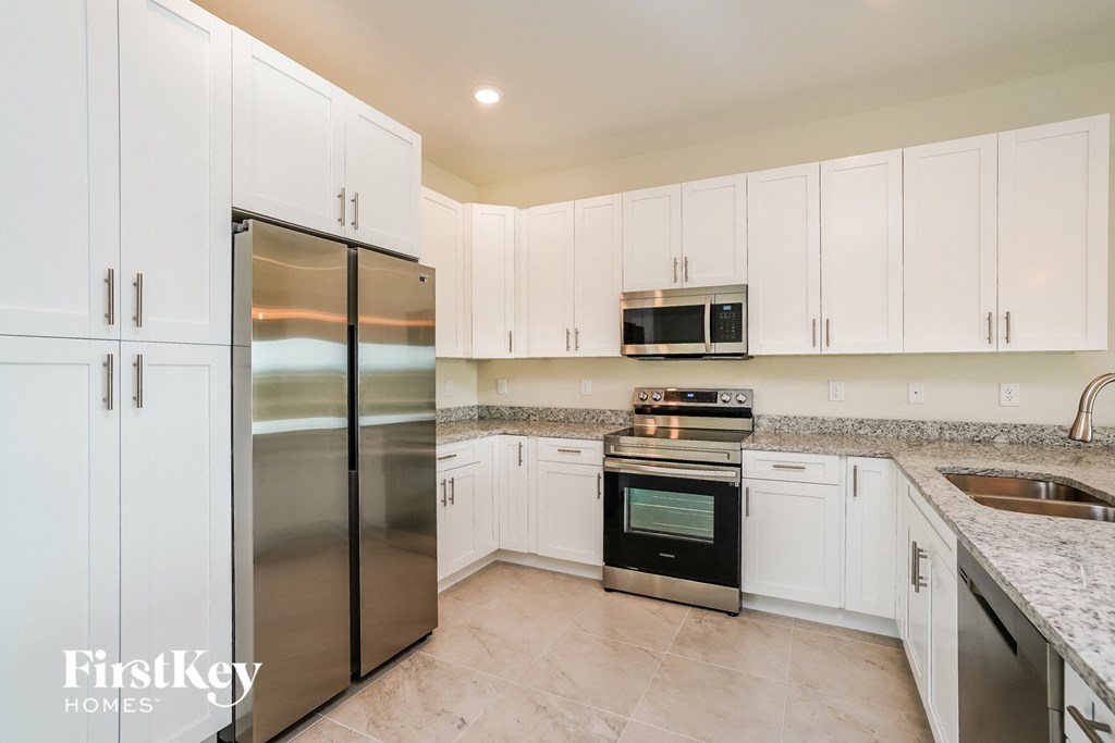 a kitchen with white cabinets and stainless steel appliances