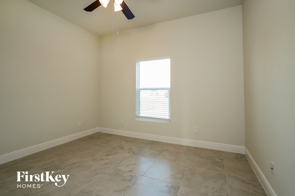 a empty room with a window and a ceiling fan