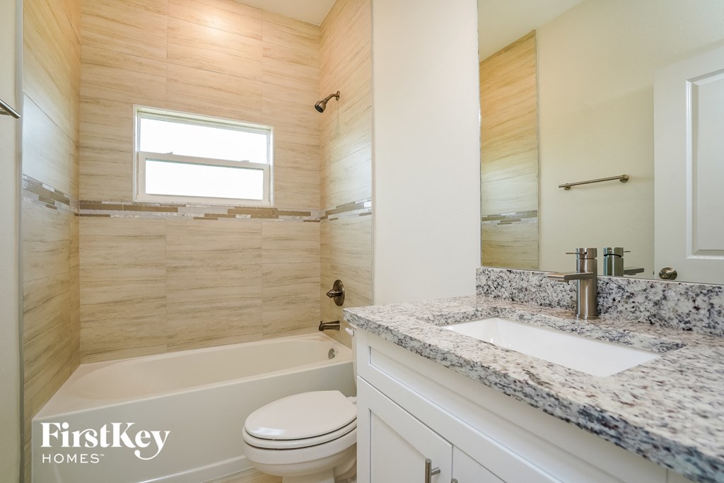 a bathroom with a toilet and a sink and a tub