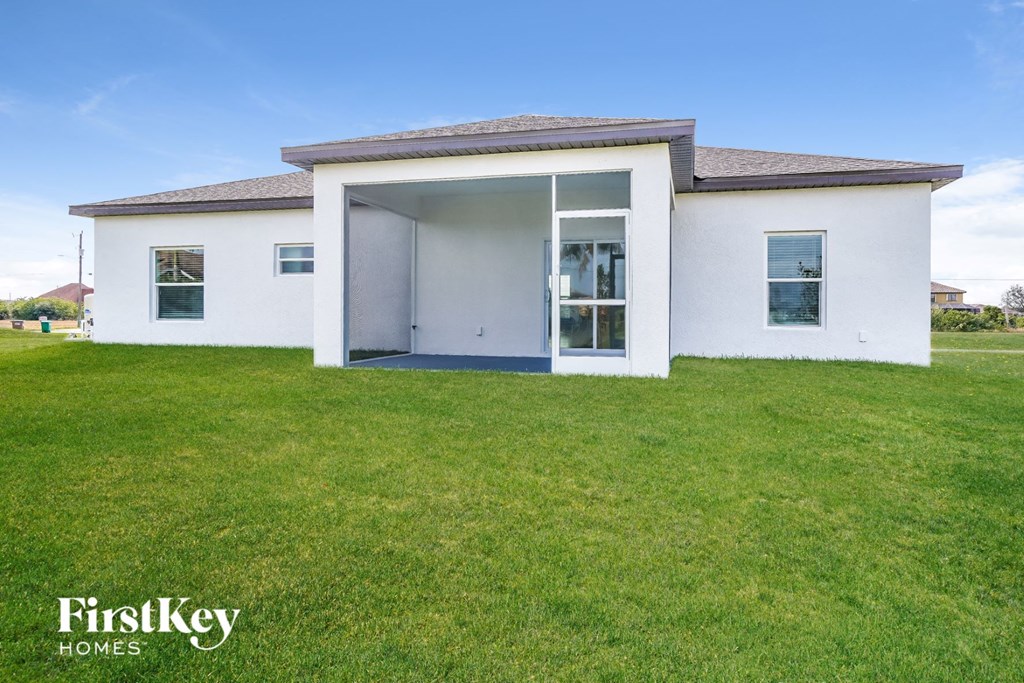 a small white house with a lawn in front of it