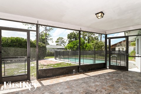 A patio with a pool and a black gate.