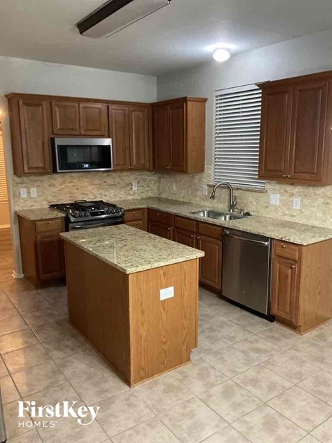 A kitchen with wooden cabinets and a granite countertop.