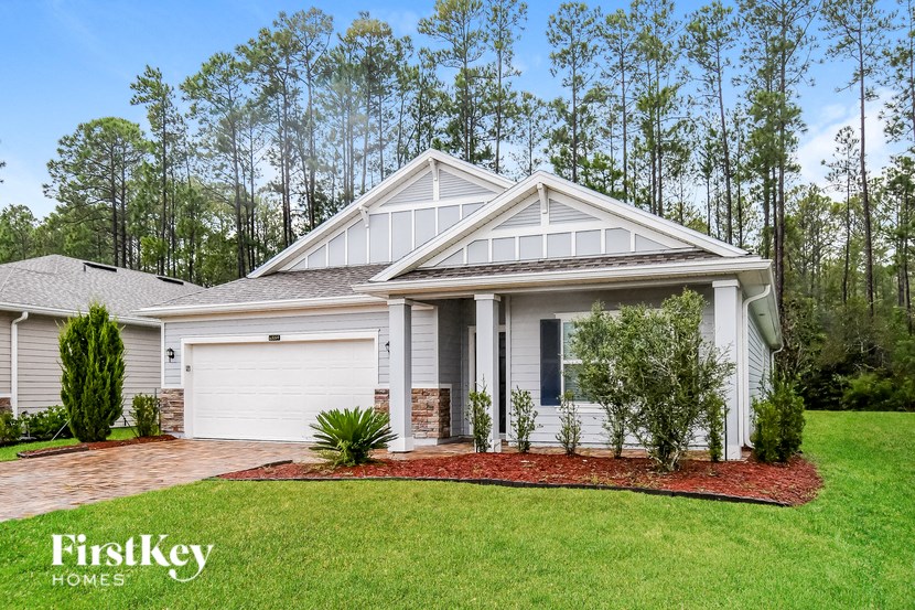 A house with a white garage door and a brick driveway.
