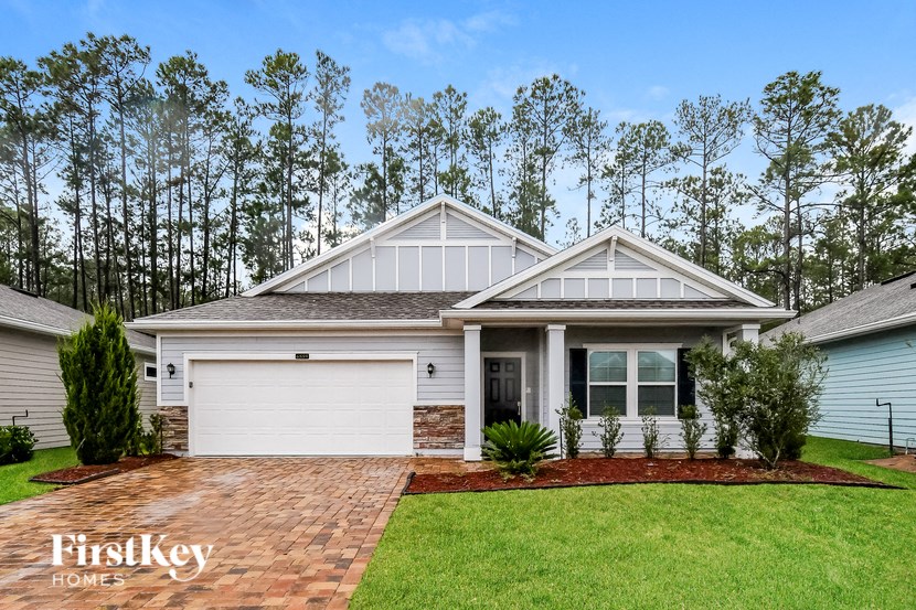 A house with a garage and a driveway in front of it.