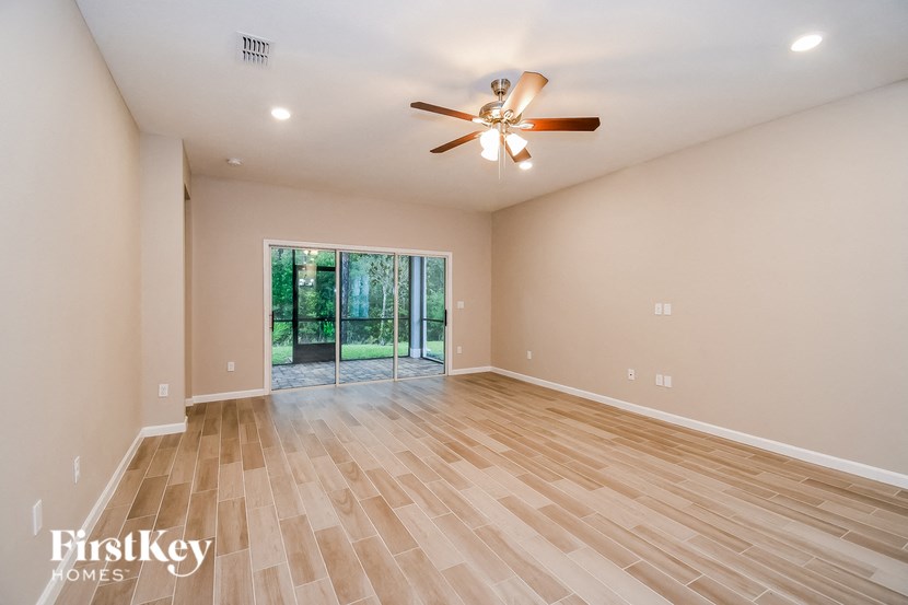 A room with a ceiling fan and wooden flooring.