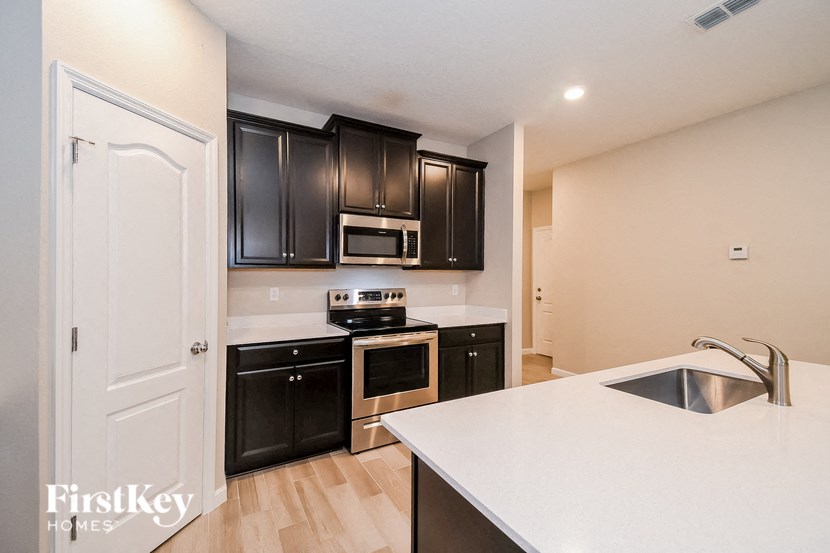 A kitchen with a white counter top and black cabinets.