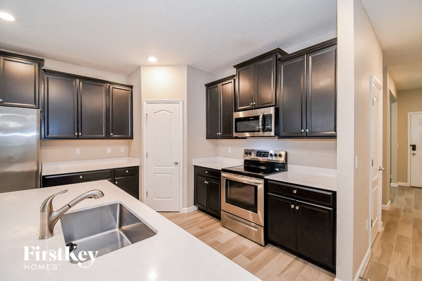 A kitchen with black cabinets and stainless steel appliances.