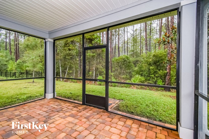 A patio with a black door and a brick floor.