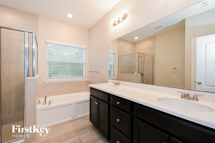 A bathroom with a white sink and a bathtub.