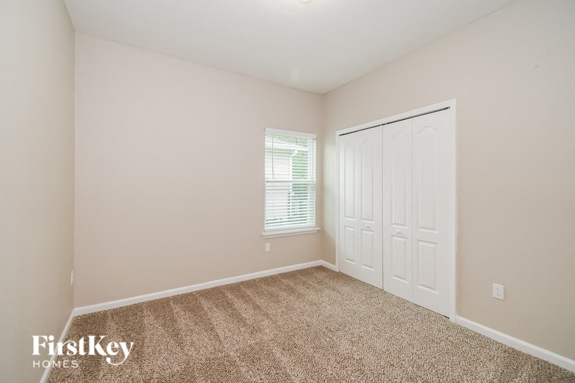 A room with a carpeted floor and a white door.