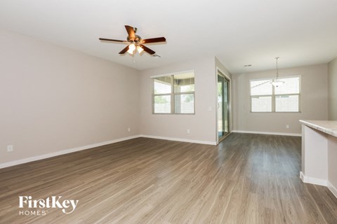 the living room and dining room with wood flooring and a ceiling fan