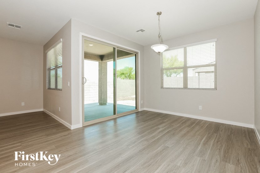 the living room of an empty house with wood flooring and a sliding glass door